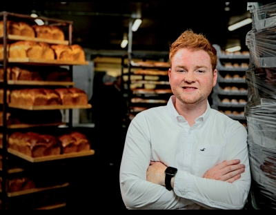 A photograph of Patrick Twomey, UL alumnus and Managing Director of Twomey's Bakery Ltd., with bakery products in the background.