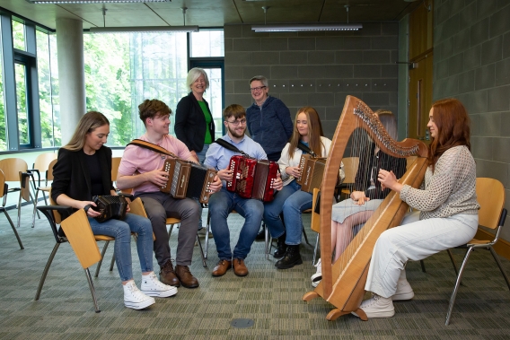 Aine Hensey and Maire N Ghrada pictured with the UL students and musical instruments
