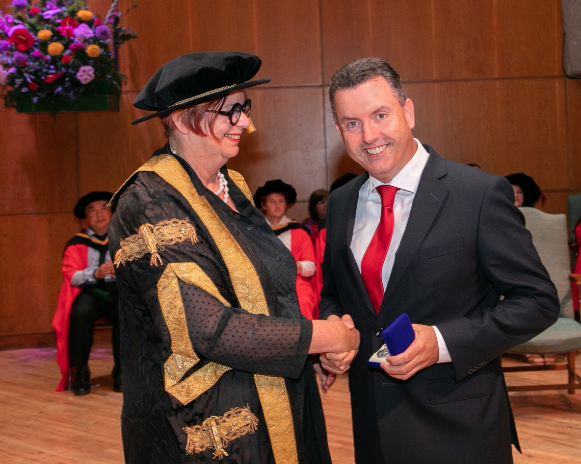 President Mey presenting the medal to John Gavin during the conferring ceremony