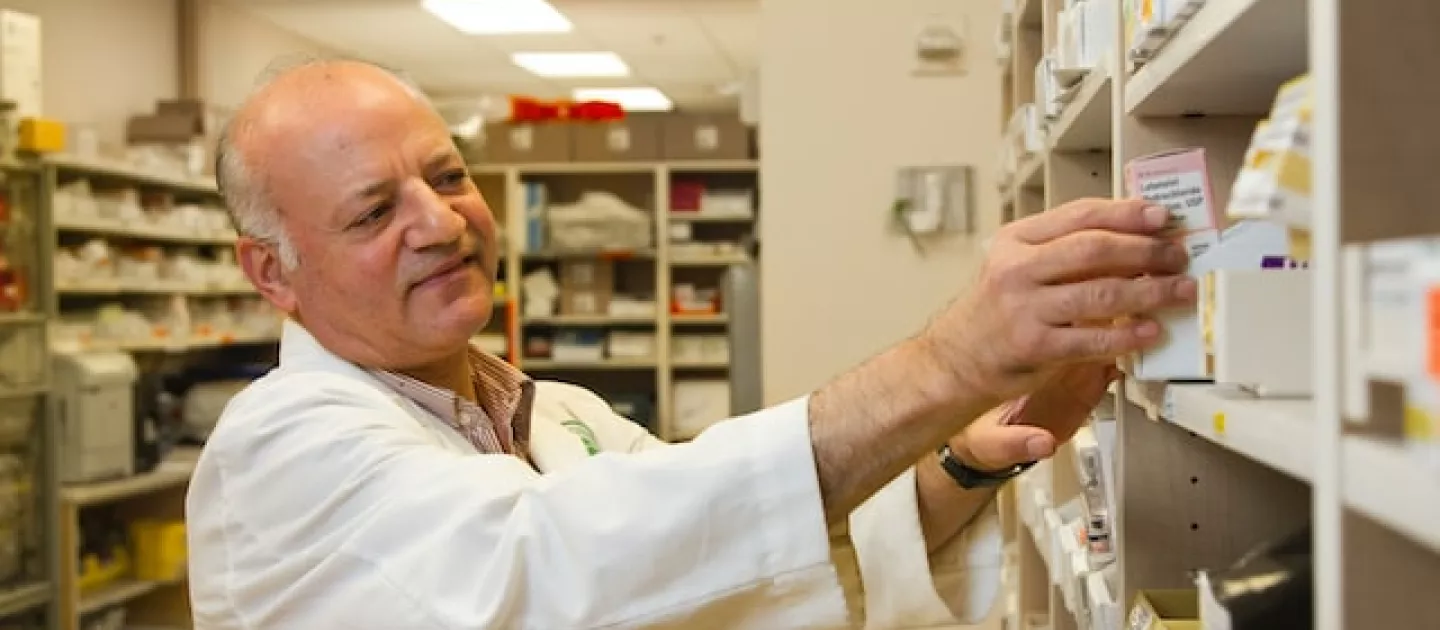 man taking medicine from shelf