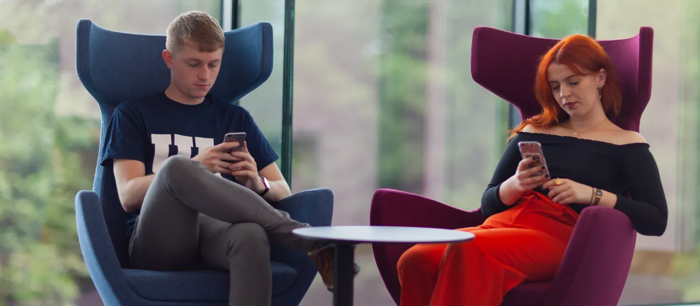 UL students in large chairs in Glucksman Library