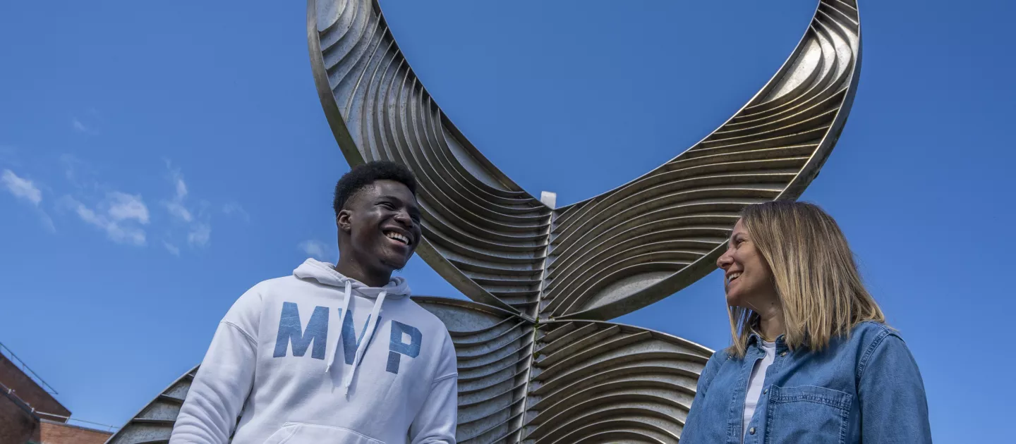 International students laughing beside Schumann building