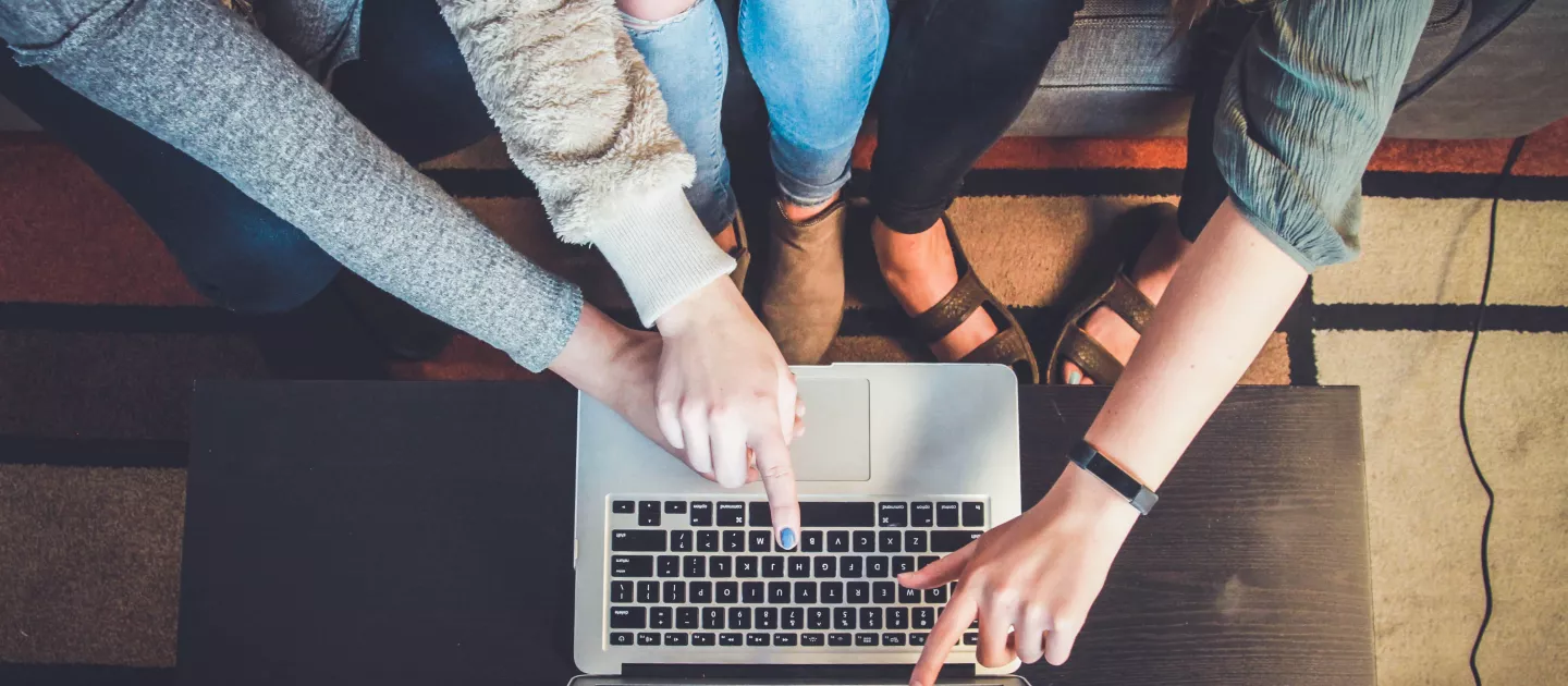 hands pointing to a laptop screen