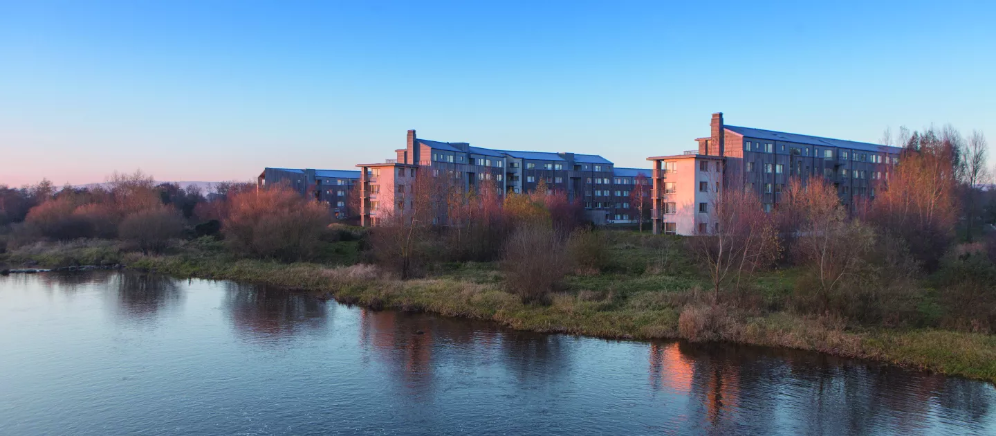 Image shows village on campus across the river