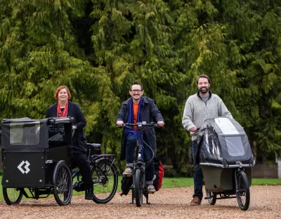 Professor Kerstin Mey, sitting on a tricycle style e-bike, Dr James Green also on a e-bike and Brian Leddin TD on an e-bike with a children's carrier in the front. 