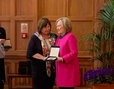 A picture of Mary Harney receiving her award from Hilary Clinton