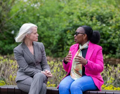 Two women sitting on a bench outside on the UL campus 