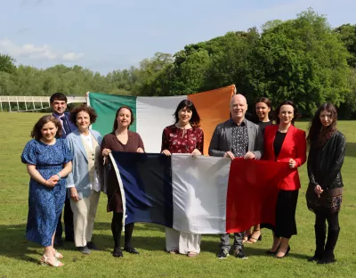 Group photo with people holding Irish and French flags