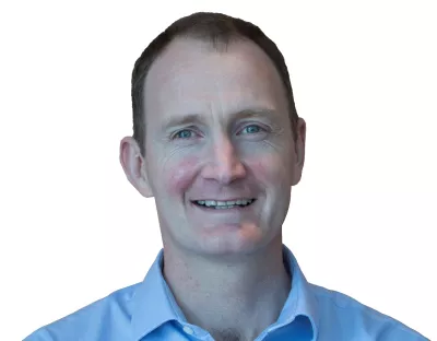 Head shot of Dr Kieran O'Sullivan wearing a blue shirt and smiling