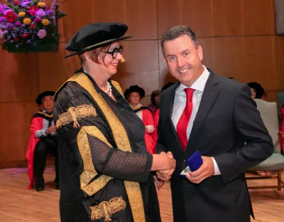 President Mey presenting the medal to John Gavin during the conferring ceremony