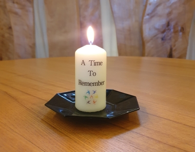 lighting candle inscribed with A Time to Remember