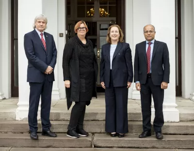 A group shot of four people on the steps of Plassey House. 