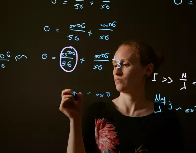 Doireann O’Kiely pictured in front of a screen with blue writing on it