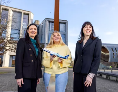 A picture of three people on the UL campus - one of them is holding a small toy plane