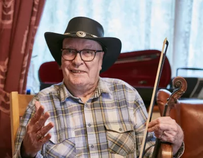 Man sitting down holding fiddle