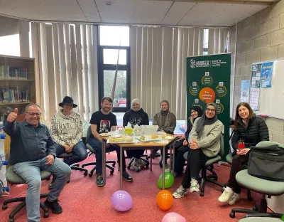 7 PhD writers gathered around a table while celebrating PhD writers week