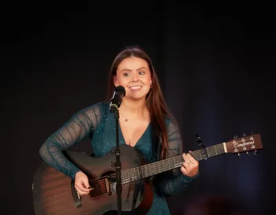 Person on stage singing and playing guitar