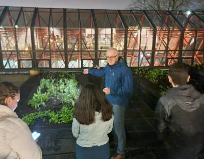 A nighttime photo of students and staff at the UL rooftop garden