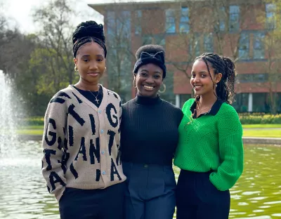 Three women standing in front of a fountain on the University of Limerick campus