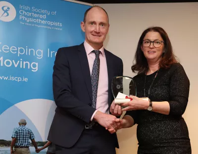 Man being presented with an award by a woman