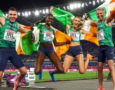 European gold medalists in the 4x400 mixed relay celebrating their win wrapped in Irish flags