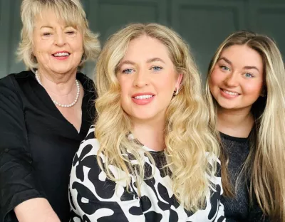 Indoor shot of three women smiling, mother, daughter and granddaughter.