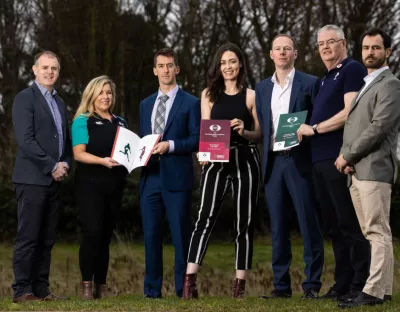 Seven people pictured holding a number of printed reports into the IRIS/IRFU rugby surveillance programme