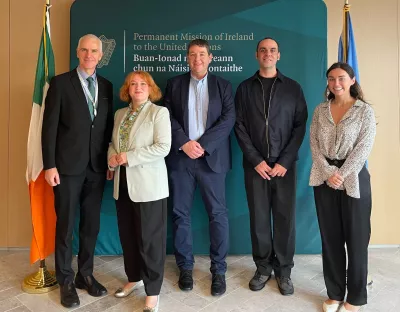 3 men and two females standing facing the camera with the Irish flag to the left hand side of them