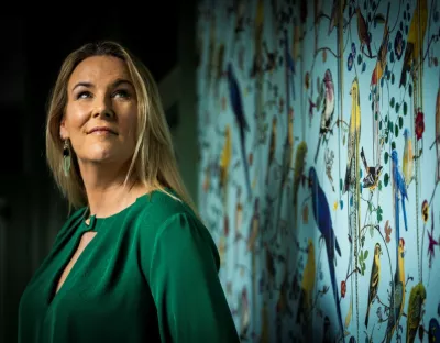 Portrait of Hannah Wrixon standing in front of vibrant wallpaper