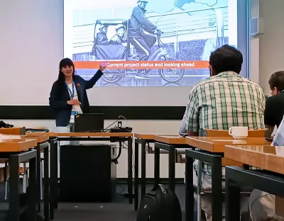 Dr. Anna Barrero presenting in front of a crowd of people.