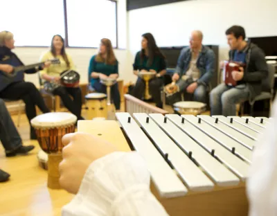 People in a circle playing musical instruments