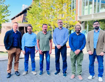 Six men standing outside the Bernal Institute in a group posing for a photo