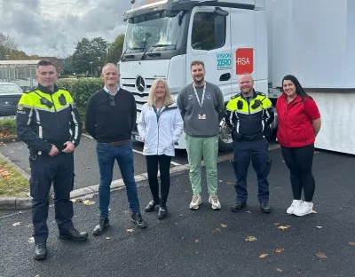 Six people standing outside the Road Safety Authority Interactive Shuttle Bus on the UL campus - two of them are Gardai in uniform