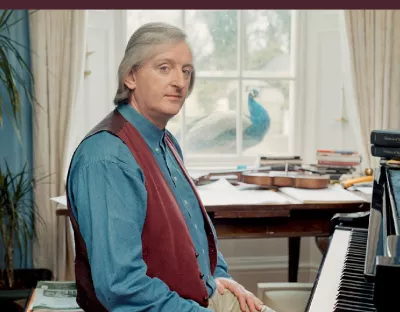 Book cover of "Mícheál Ó Súilleabháin A Life in Music" showing him sitting at a piano.