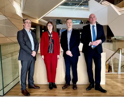 A picture of four people indoors - they are three men and one woman