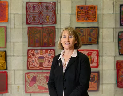 Photo of woman standing in front of multi-coloured fabric panels