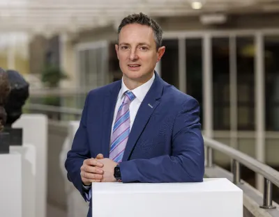 A picture of Professor Kevin M Ryan standing at a white column in UL