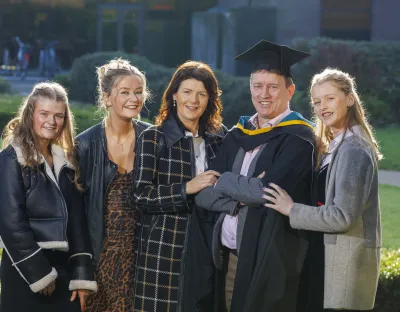 a family of four women and one man smiling at camera