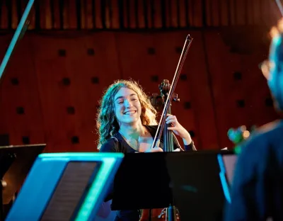 Violinist looking at sheet music and smiling