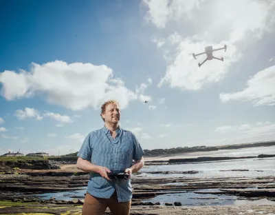 A picture of Professor Gerard Dooly operating a drone on a beach