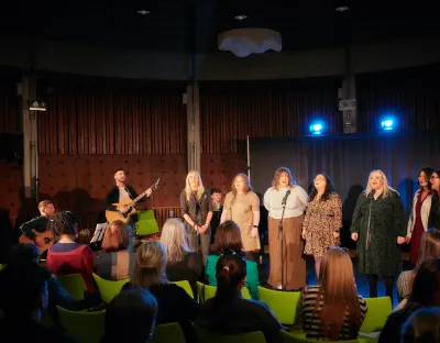 Seven singers and two guitarists performing to audience