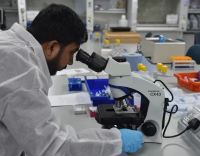 student looking into microscope