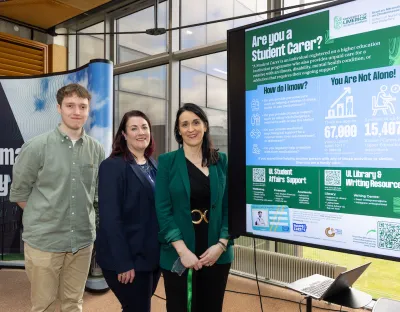 Three people standing beside an infographic with information about supports for student carers