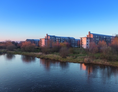 Image shows village on campus across the river