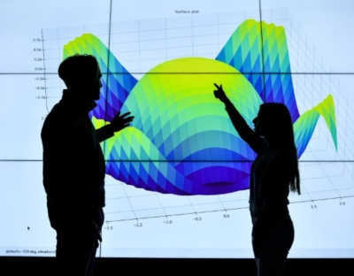 Two people standing in front of Data Visualisation