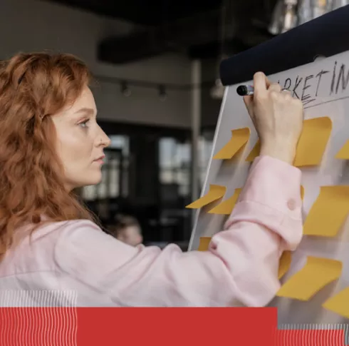 woman at a whiteboard with yellow post-its