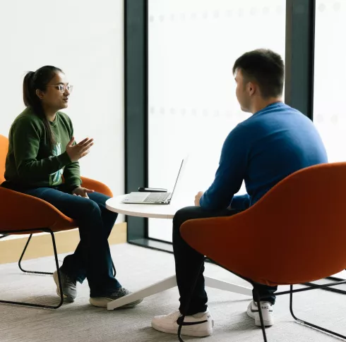 Two students speaking in the library