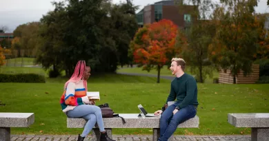 Two students sitting outside on the plaza, UL Campus