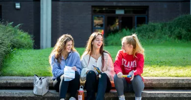 3 students sitting and laughing