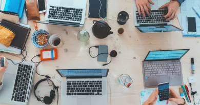 Laptops, devices, and coffee cups on a table